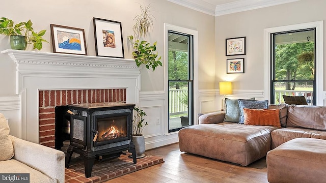 sitting room with a wainscoted wall, ornamental molding, a decorative wall, and wood finished floors