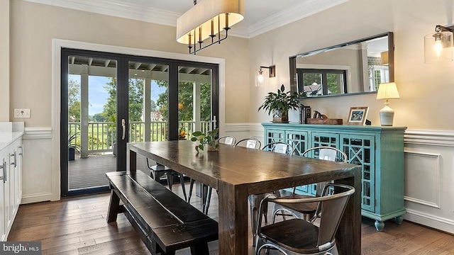 dining space featuring a wainscoted wall, a healthy amount of sunlight, crown molding, and hardwood / wood-style floors