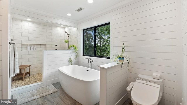 full bath with a soaking tub, visible vents, toilet, wood finished floors, and a walk in shower