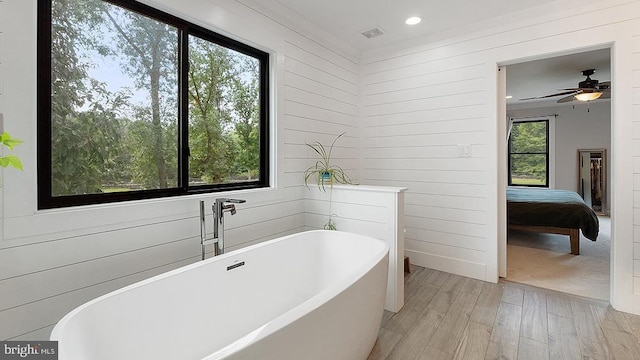 full bath with recessed lighting, ensuite bathroom, wooden walls, wood finished floors, and a freestanding tub