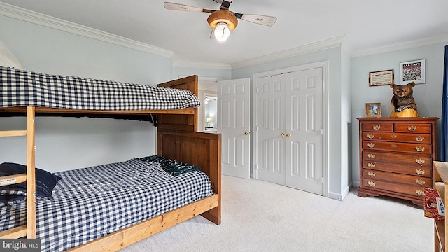 carpeted bedroom featuring ornamental molding, a closet, a ceiling fan, and baseboards