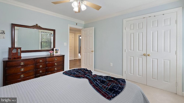 bedroom featuring a closet, ornamental molding, carpet flooring, ceiling fan, and baseboards