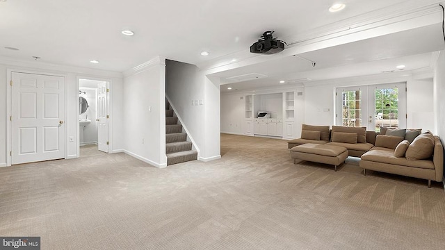 living area featuring light carpet, french doors, ornamental molding, and stairway