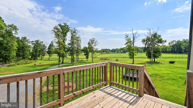 wooden terrace with a yard and a rural view