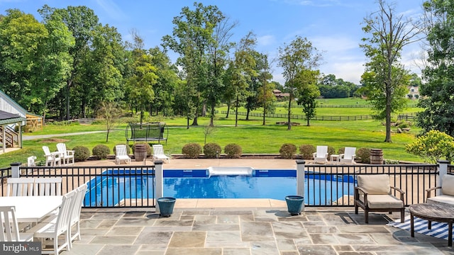 view of swimming pool with a trampoline, a fenced in pool, a lawn, a patio area, and fence