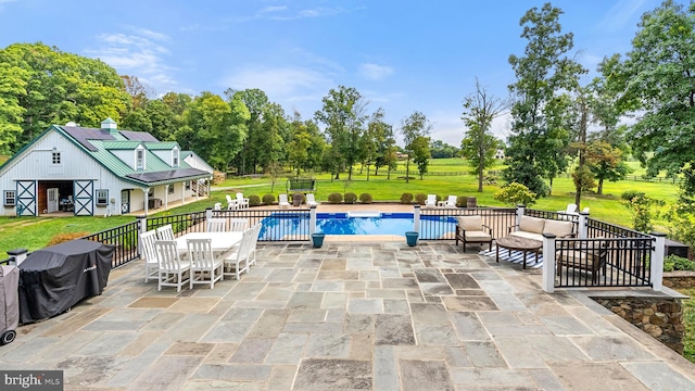 pool featuring an outdoor structure, a lawn, and a patio