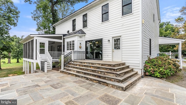 rear view of property with a patio and a sunroom