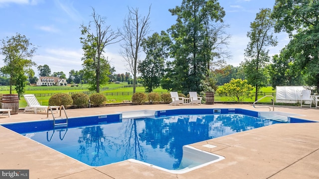 outdoor pool with fence and a patio