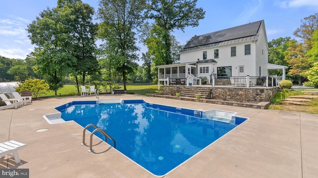 outdoor pool with a sunroom and a patio area