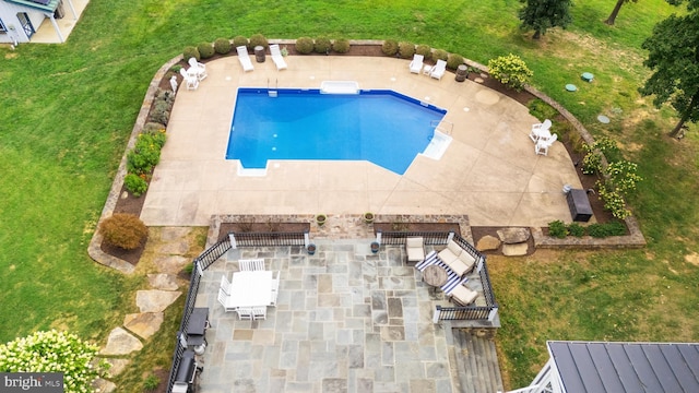 outdoor pool featuring a yard and a patio