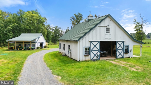 view of barn with a yard and driveway