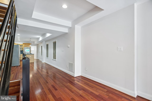 interior space featuring baseboards, visible vents, dark wood-style flooring, a tray ceiling, and recessed lighting