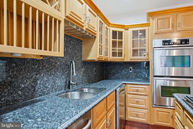 kitchen featuring a sink, glass insert cabinets, decorative backsplash, and stainless steel double oven