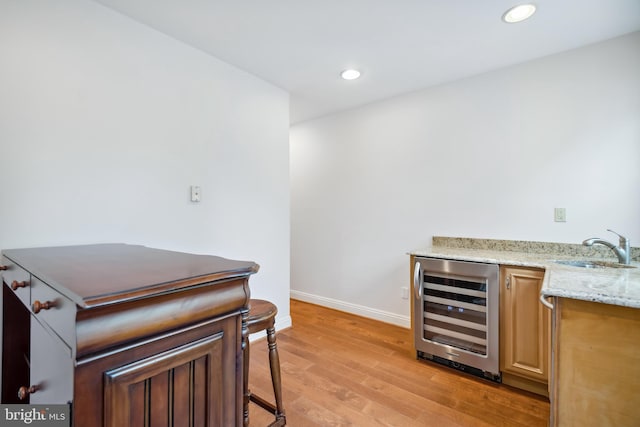 bar with recessed lighting, beverage cooler, a sink, baseboards, and light wood-type flooring