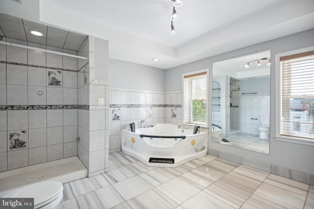 bathroom with tile patterned flooring, toilet, tile walls, a shower stall, and a whirlpool tub