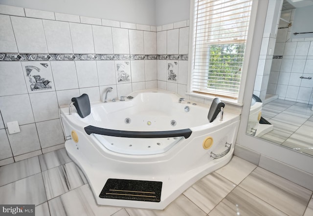 bathroom with a jetted tub, tile walls, and tile patterned floors