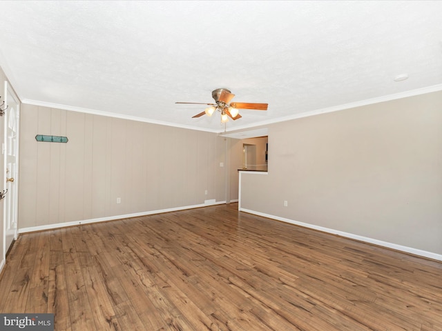 empty room featuring hardwood / wood-style floors, baseboards, ceiling fan, ornamental molding, and a textured ceiling