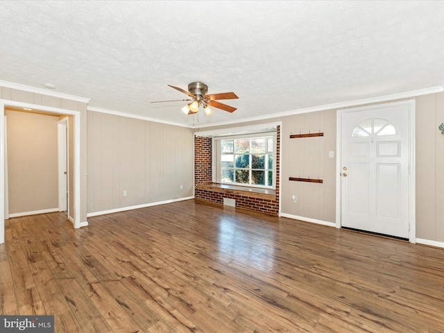 entryway featuring ceiling fan, hardwood / wood-style flooring, brick wall, ornamental molding, and a textured ceiling