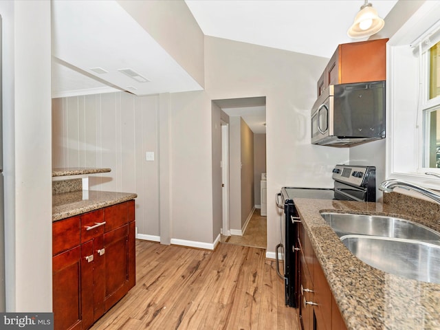 kitchen featuring light stone counters, sink, pendant lighting, light hardwood / wood-style flooring, and appliances with stainless steel finishes