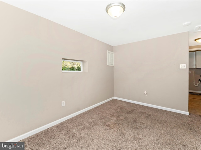 spare room featuring baseboards and carpet