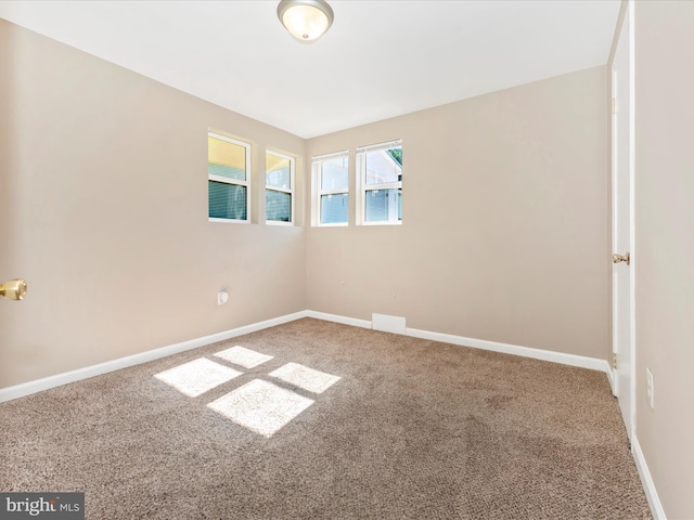 empty room featuring carpet flooring and baseboards