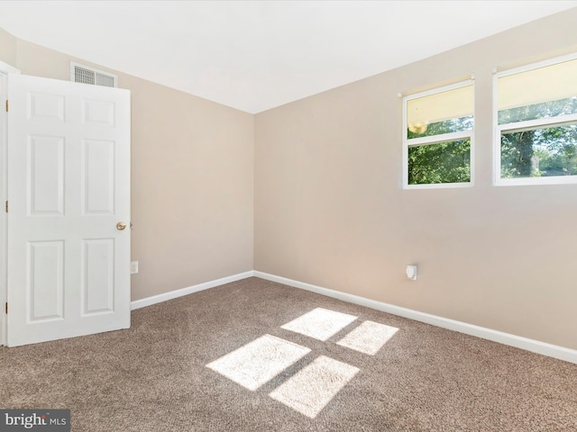 unfurnished room featuring baseboards, visible vents, and carpet floors