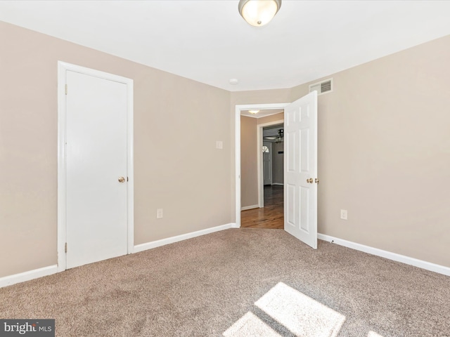 unfurnished bedroom featuring visible vents, carpet floors, and baseboards