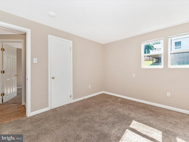 carpeted spare room with baseboards