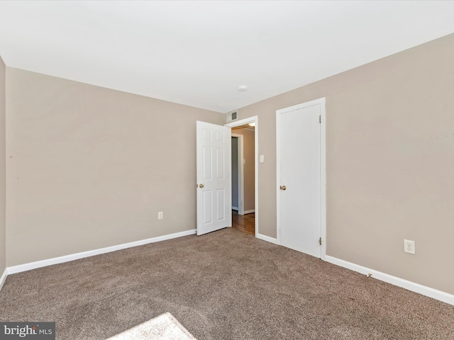 unfurnished bedroom with visible vents, baseboards, and carpet flooring