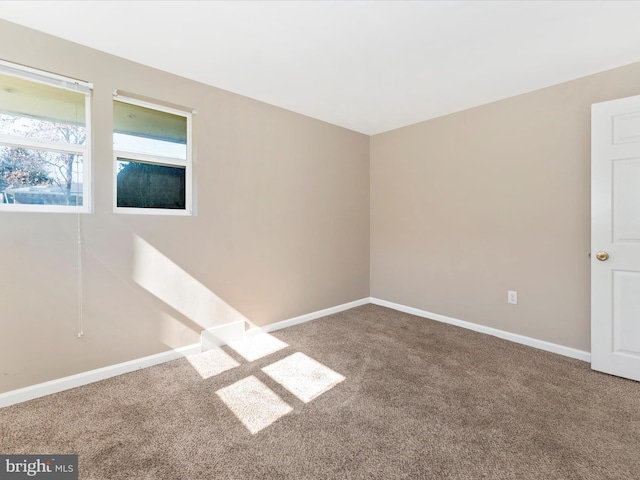 empty room with baseboards and carpet