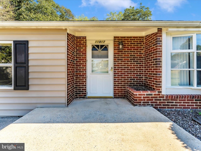 doorway to property with brick siding