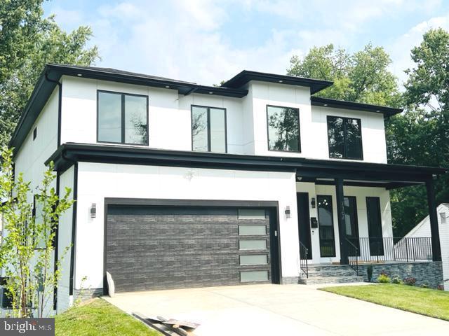 contemporary house featuring covered porch and a garage