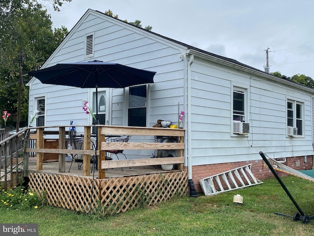 rear view of house with a yard, a deck, and cooling unit