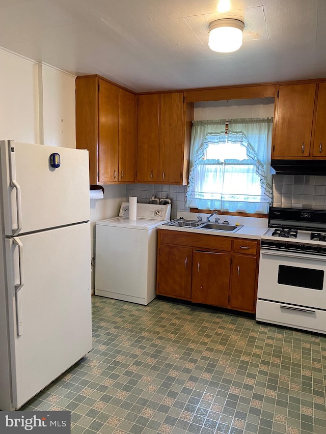 kitchen featuring backsplash, washer / dryer, sink, and white appliances