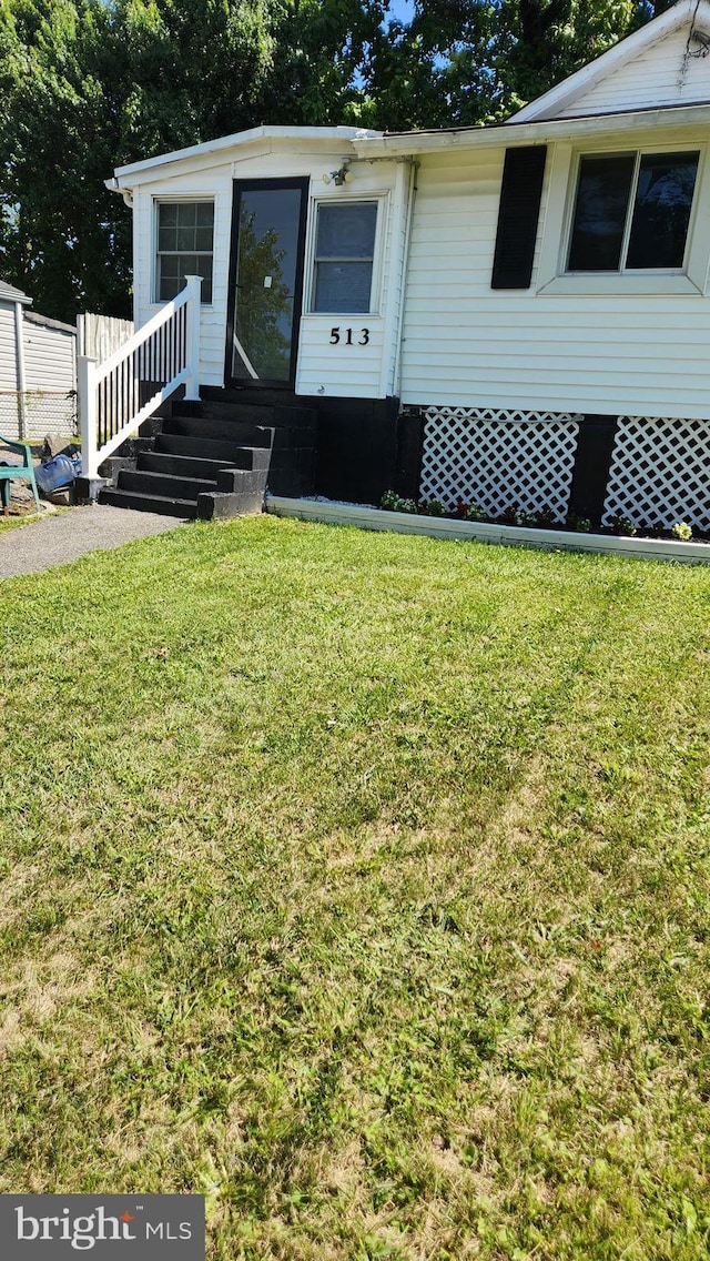 doorway to property with a lawn