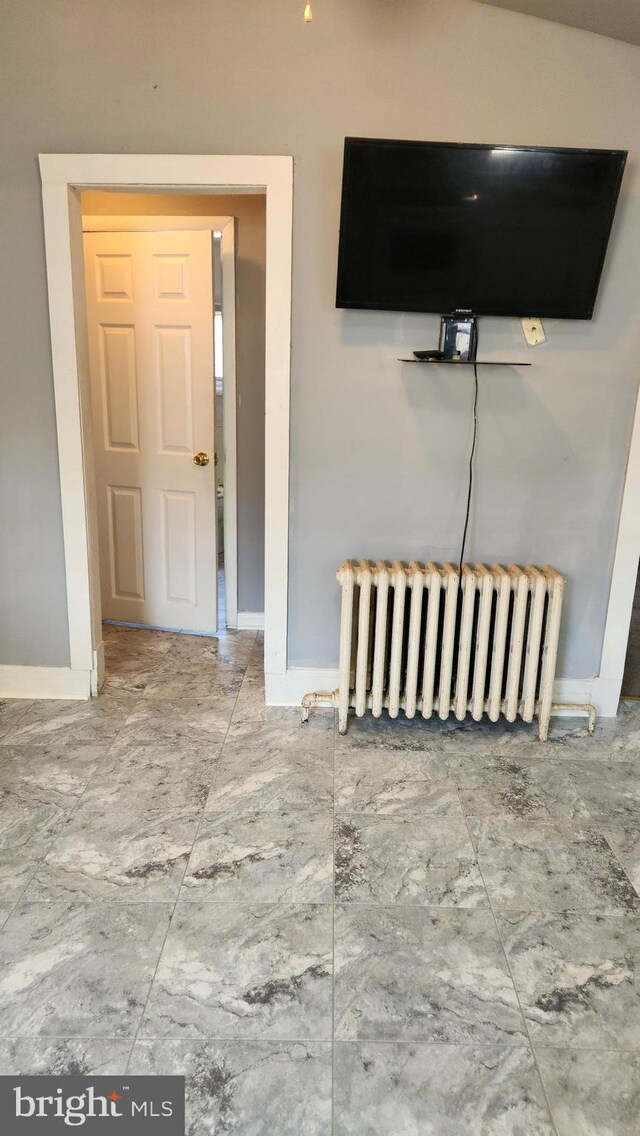 interior space with tile patterned flooring and radiator heating unit