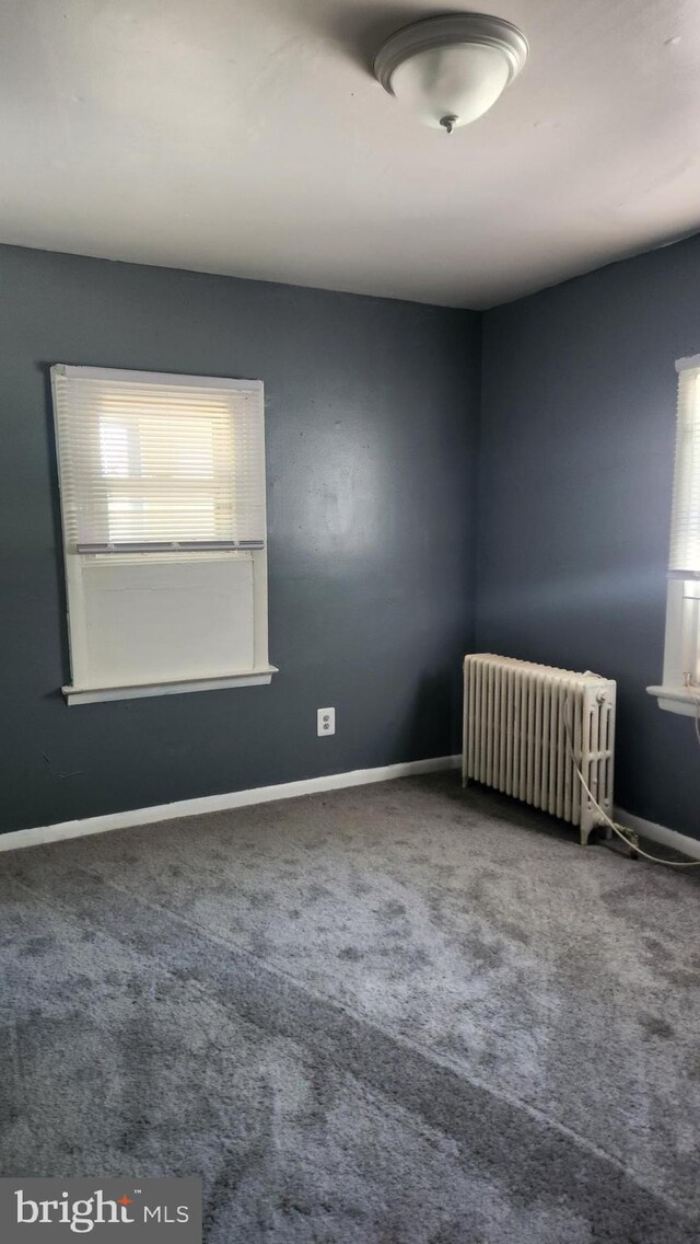 carpeted empty room with radiator