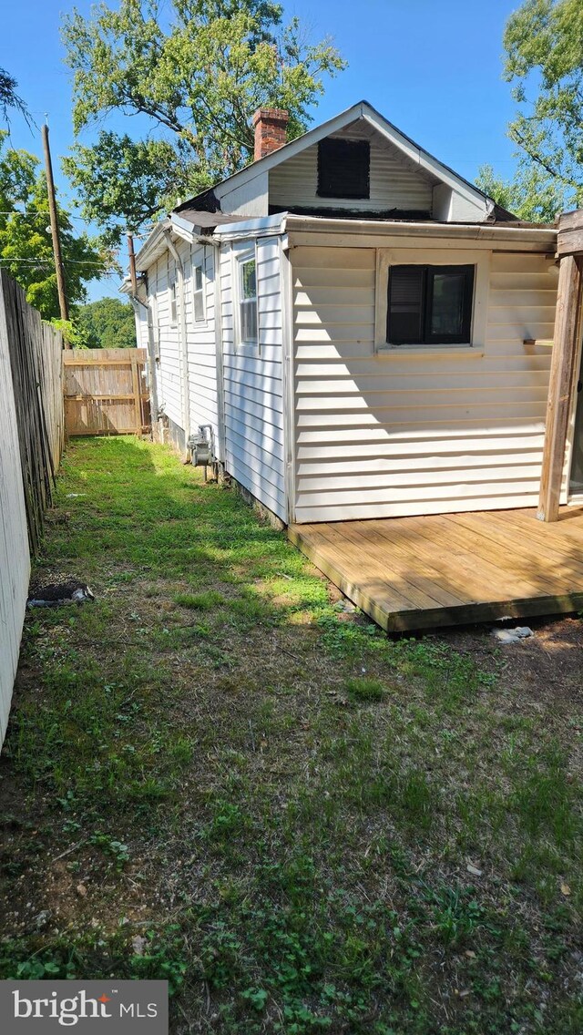 view of side of home featuring a deck and a yard