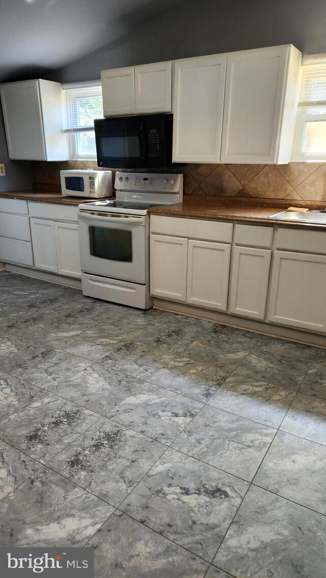 kitchen with white appliances, white cabinets, tasteful backsplash, and tile patterned floors