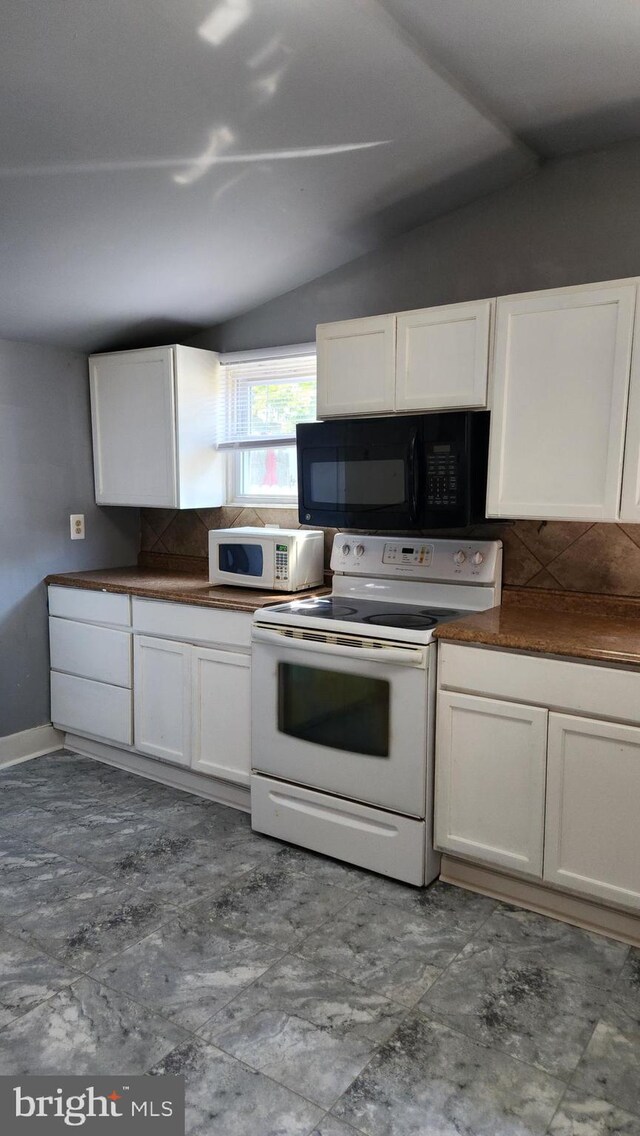 kitchen with decorative backsplash, white cabinetry, tile patterned flooring, lofted ceiling, and white appliances