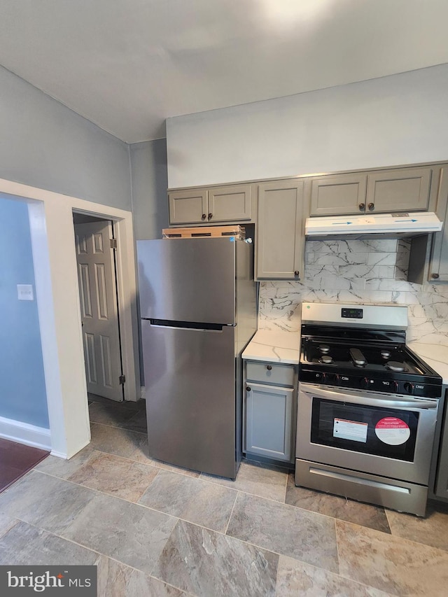 kitchen with light tile patterned floors, appliances with stainless steel finishes, gray cabinets, and decorative backsplash