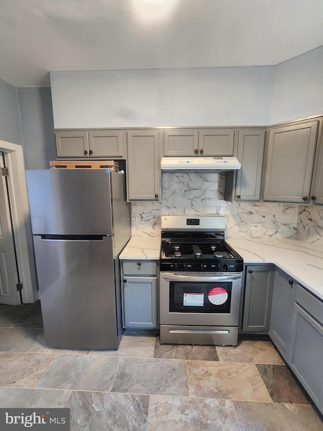 kitchen featuring decorative backsplash, light tile patterned floors, gray cabinets, and stainless steel appliances