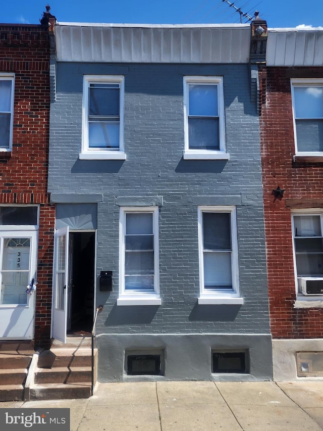 view of property featuring entry steps and brick siding