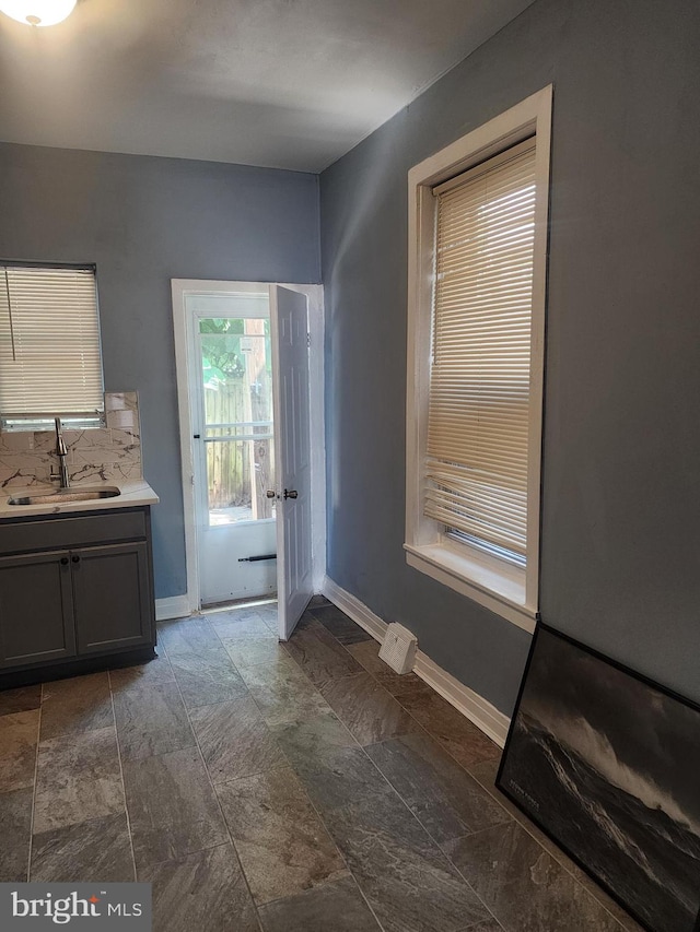 interior space featuring backsplash, tile patterned floors, and vanity