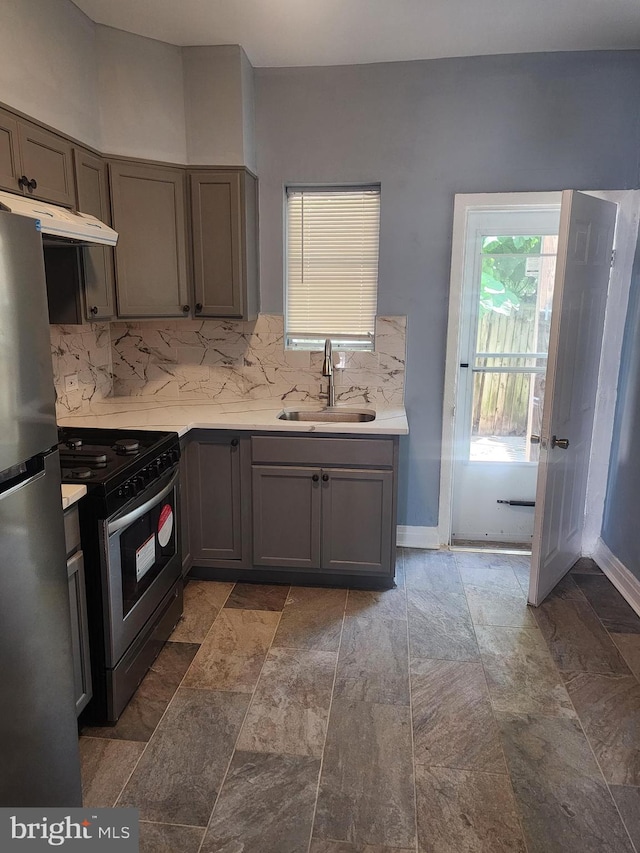 kitchen with gas range, sink, stainless steel fridge, and tile patterned floors