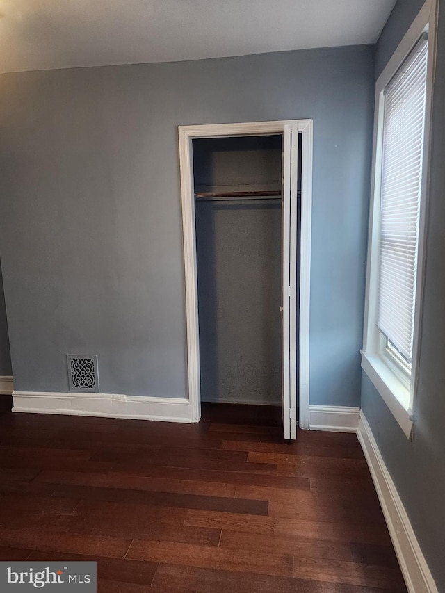 unfurnished bedroom featuring a closet and hardwood / wood-style floors