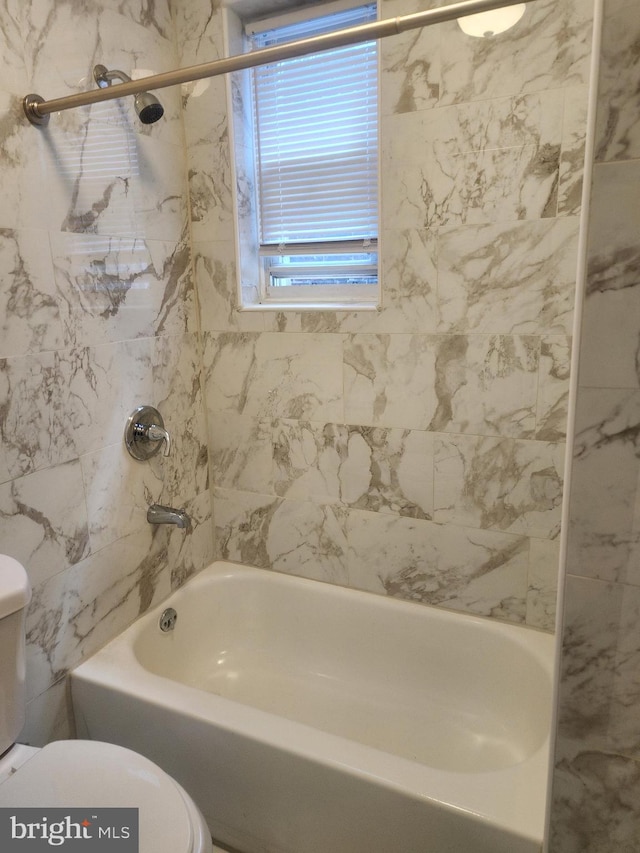 bathroom with tiled shower / bath and toilet