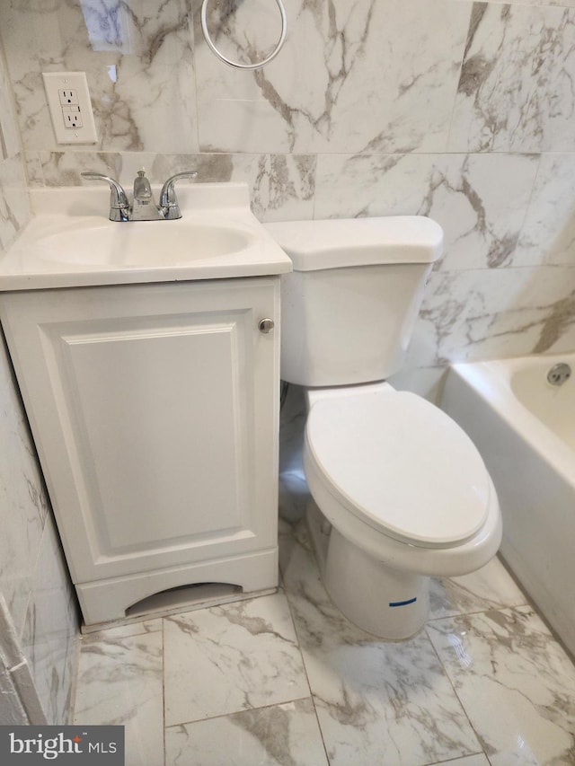 bathroom with toilet, tile patterned flooring, vanity, and tile walls