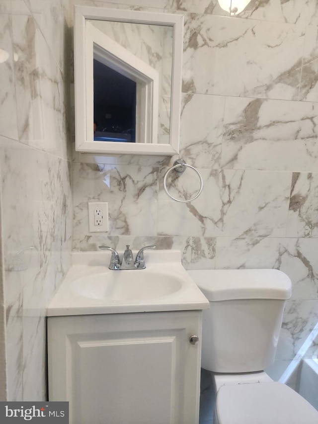 bathroom with vanity and tile walls