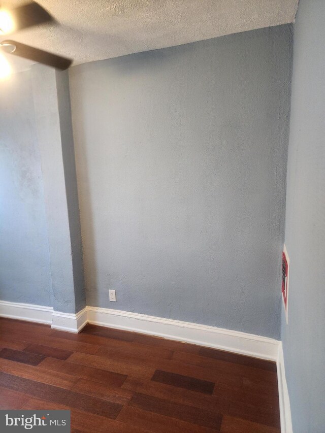 empty room with hardwood / wood-style floors and a textured ceiling